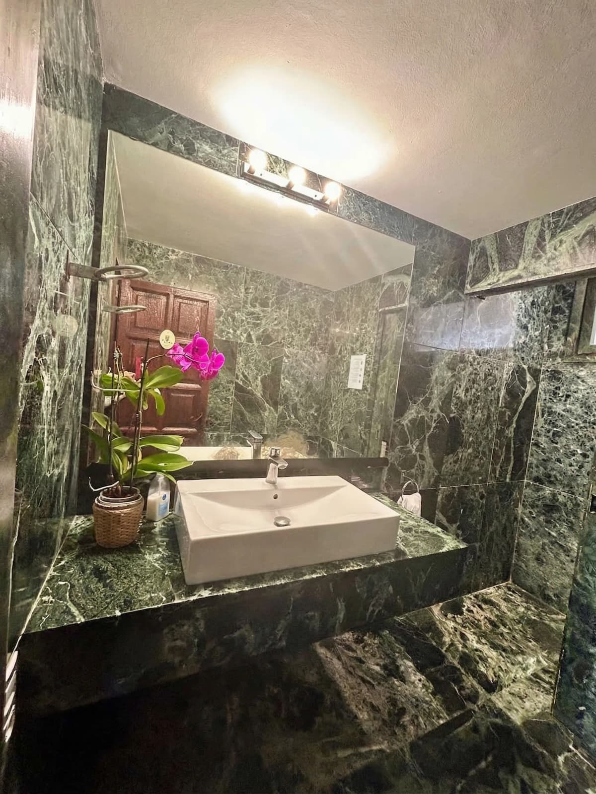 Green marble bathroom with orchid
