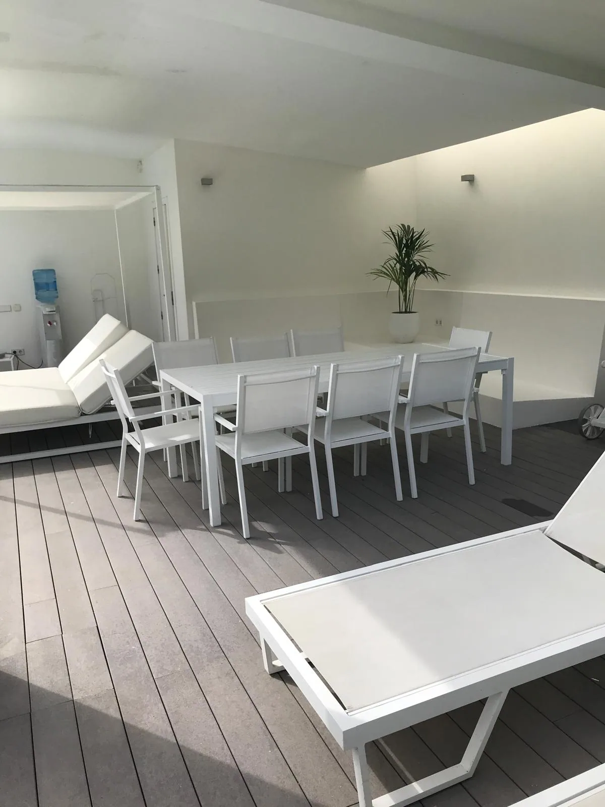 Covered terrace with outdoor dining area and sun loungers